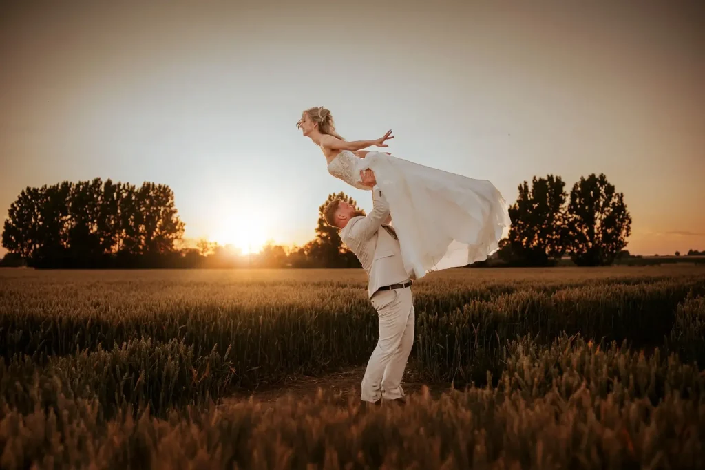 Man holding woman in the air on their wedding day